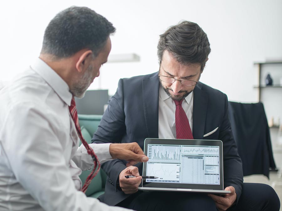 business-partner-meeting-900C Business men discussing charts on a computer screen